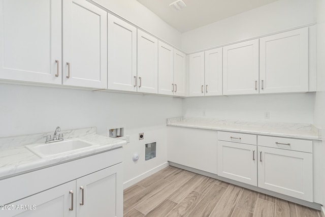 laundry room with sink, cabinets, electric dryer hookup, washer hookup, and light hardwood / wood-style floors