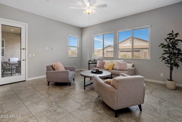 living room featuring baseboards and a ceiling fan