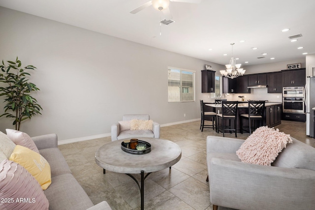 living room with ceiling fan with notable chandelier, recessed lighting, visible vents, and baseboards