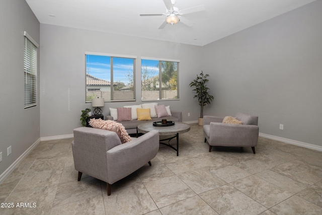 living area featuring baseboards and a ceiling fan