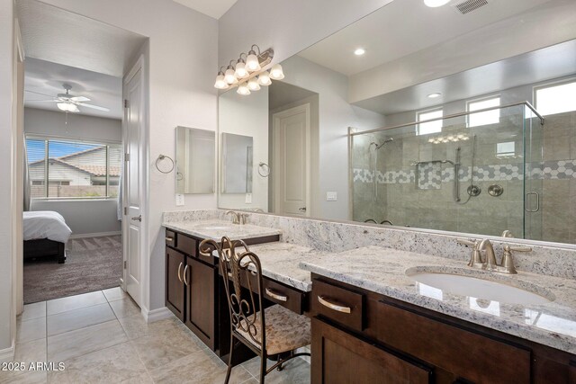 full bath featuring a stall shower, tile patterned flooring, a sink, and double vanity