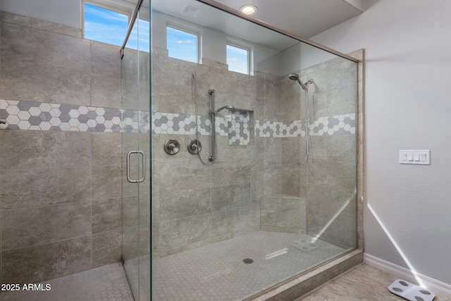 bathroom with a shower stall and baseboards