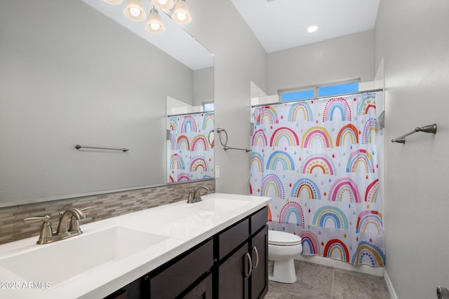 full bathroom with toilet, tasteful backsplash, double vanity, and a sink