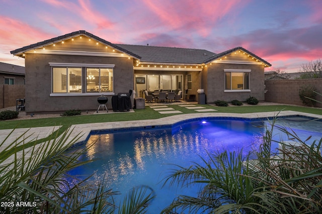 back of property featuring a fenced in pool, a fenced backyard, a patio, and stucco siding