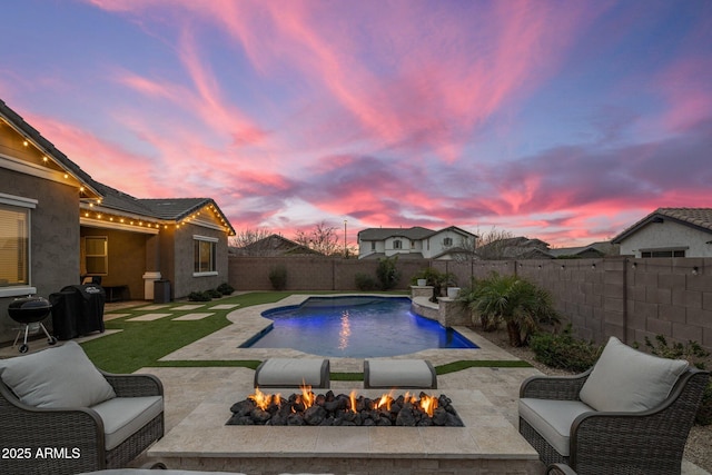 pool at dusk featuring a fire pit, a patio, a fenced backyard, and a fenced in pool