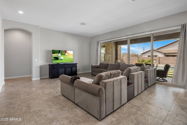 living room featuring baseboards, visible vents, and arched walkways