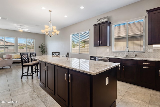 kitchen with open floor plan, a kitchen island, a sink, and decorative backsplash