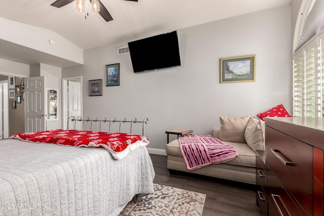 bedroom featuring dark wood-style floors, lofted ceiling, baseboards, visible vents, and ceiling fan