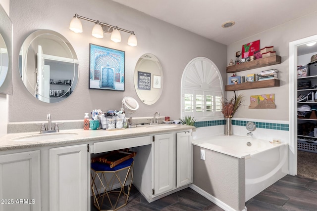 bathroom featuring a bath, double vanity, a sink, and wood finished floors