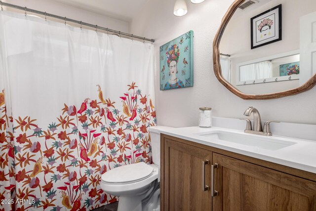 bathroom featuring visible vents, toilet, a shower with shower curtain, and vanity