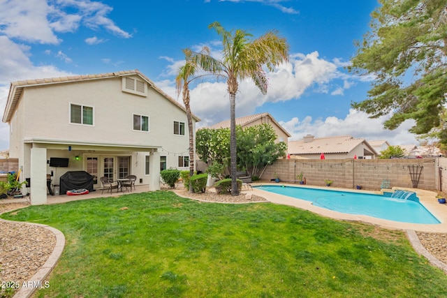 back of property with stucco siding, a patio, a fenced backyard, a fenced in pool, and a yard