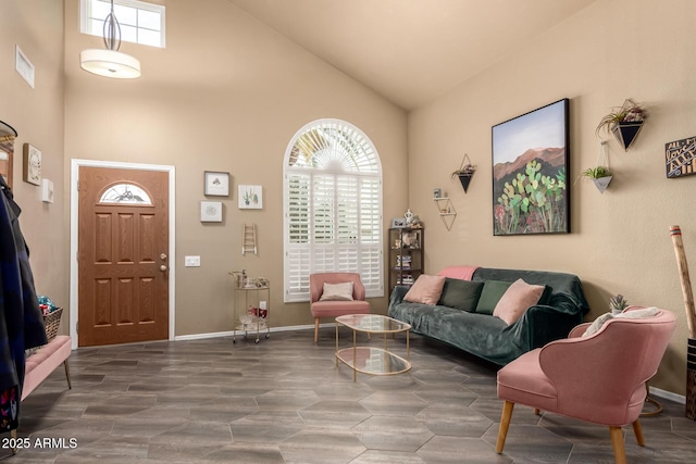 living room featuring baseboards, visible vents, and high vaulted ceiling