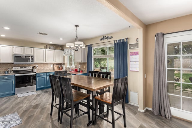 dining room with baseboards, visible vents, a chandelier, and recessed lighting
