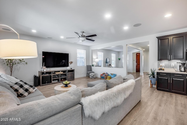 living room with decorative columns, ceiling fan, and light hardwood / wood-style floors