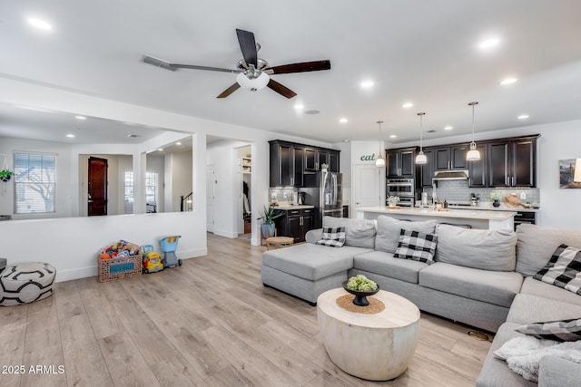 living room featuring ceiling fan and light hardwood / wood-style floors