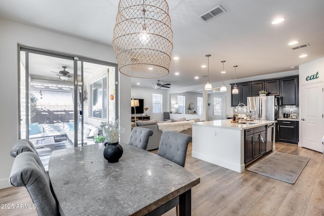 dining room with sink, ceiling fan, and light hardwood / wood-style flooring