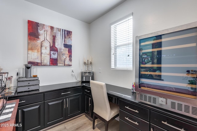 home office featuring built in desk and light hardwood / wood-style floors