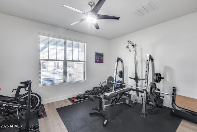 exercise room with ceiling fan and light wood-type flooring