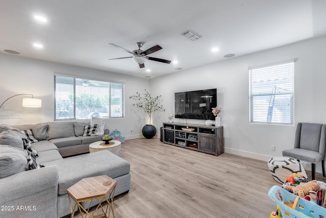 living room with ceiling fan and light wood-type flooring