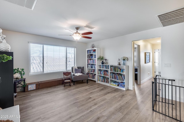 sitting room with ceiling fan and light hardwood / wood-style flooring