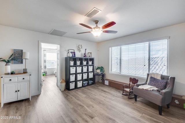 living area featuring ceiling fan and light hardwood / wood-style flooring