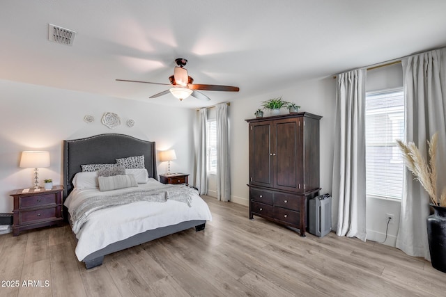 bedroom featuring multiple windows, light hardwood / wood-style flooring, and ceiling fan