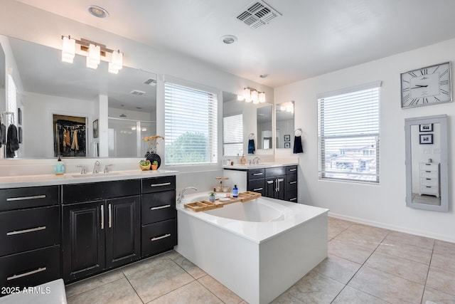 bathroom with walk in shower, vanity, and tile patterned flooring