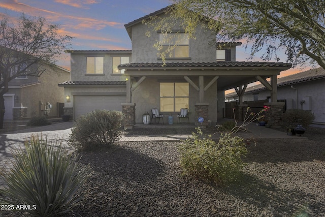 back house at dusk with a garage