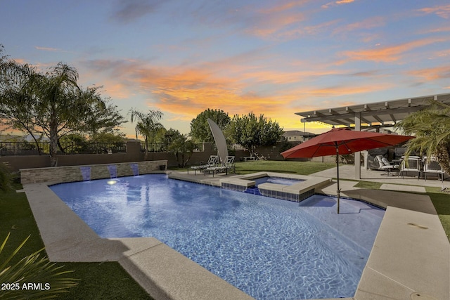 pool at dusk with an in ground hot tub, a patio area, and a pergola