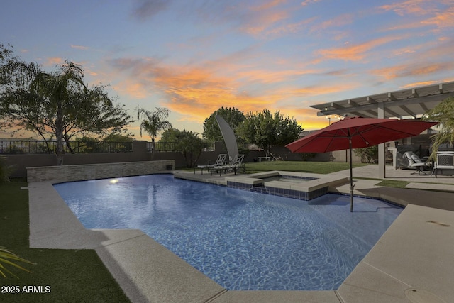 pool at dusk featuring an in ground hot tub and a patio area