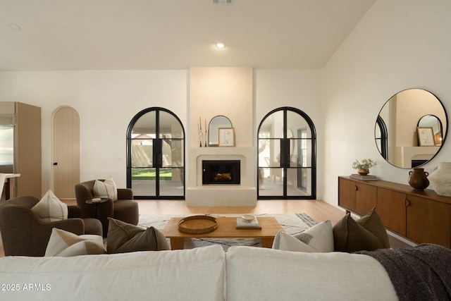 living room featuring visible vents, wood finished floors, and a fireplace