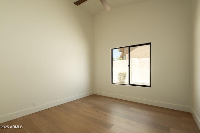 empty room with baseboards, light wood-type flooring, a ceiling fan, and high vaulted ceiling