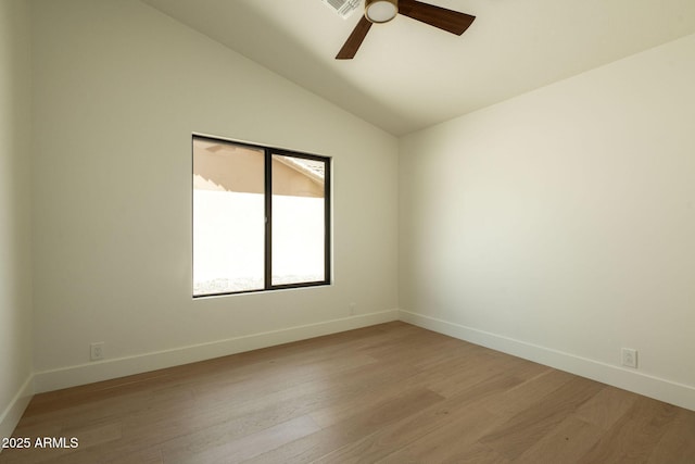 empty room featuring baseboards, light wood-type flooring, ceiling fan, and vaulted ceiling