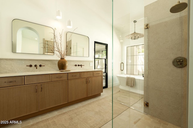 bathroom with tasteful backsplash, a sink, double vanity, a walk in shower, and a freestanding bath