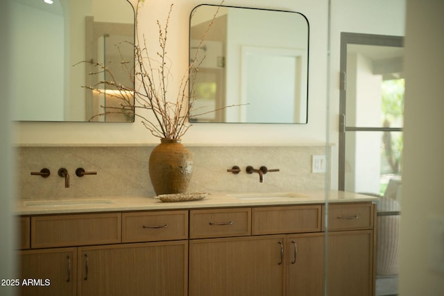 bathroom featuring double vanity, backsplash, and a sink