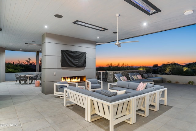 patio terrace at dusk with an outdoor living space with a fireplace