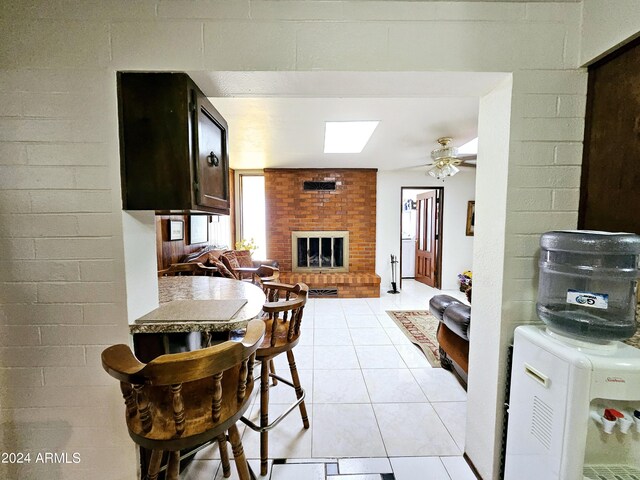 2201 E 7th St, Douglas, AZ 85607 - kitchen featuring a brick fireplace, light tile patterned flooring, and a ceiling fan