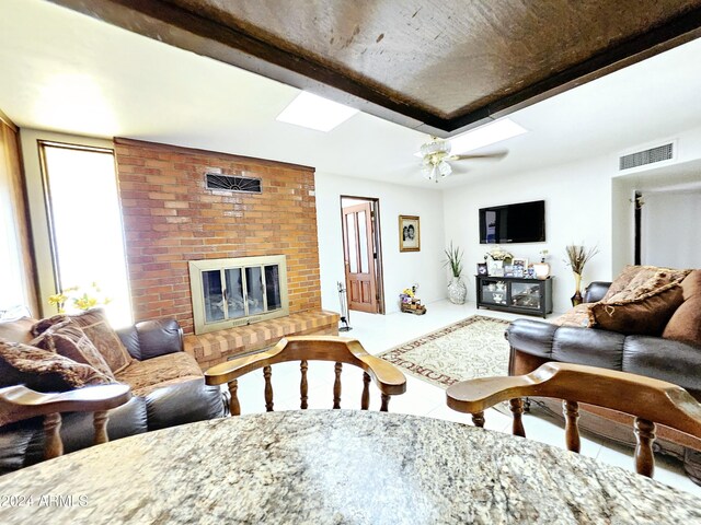 2201 E 7th St, Douglas, AZ 85607 - tiled living area featuring a fireplace, ceiling fan, and a skylight