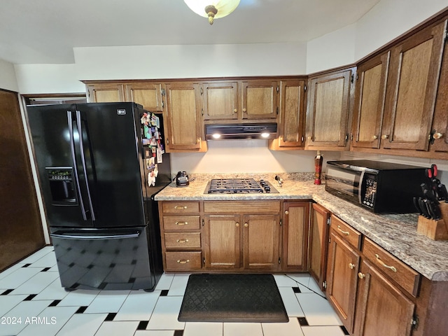 2201 E 7th St, Douglas, AZ 85607 - kitchen featuring black appliances, under cabinet range hood, light stone counters, and brown cabinets