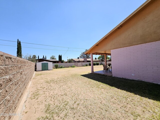 2201 E 7th St, Douglas, AZ 85607 - fenced backyard featuring a storage unit and a patio area