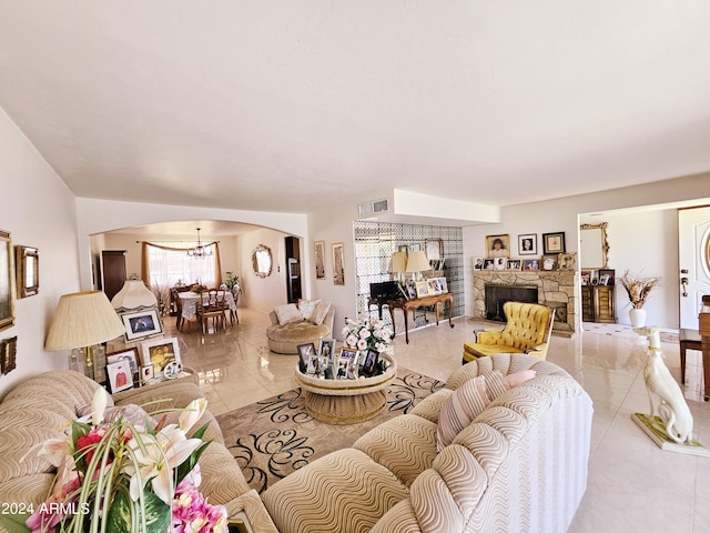 2201 E 7th St, Douglas, AZ 85607 - living area featuring arched walkways, light tile patterned floors, a chandelier, and a fireplace