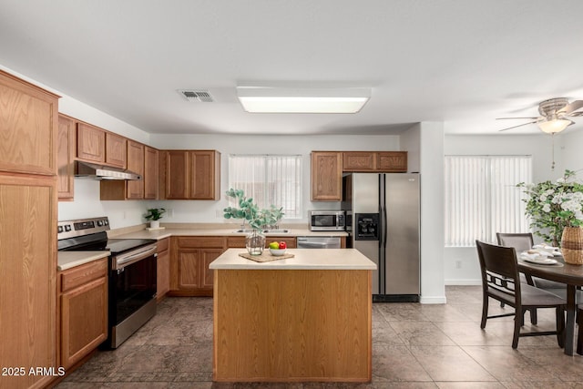 6515 W Hughes Dr, Phoenix, AZ 85043 - kitchen with stainless steel appliances, under cabinet range hood, light countertops, and healthy amount of natural light