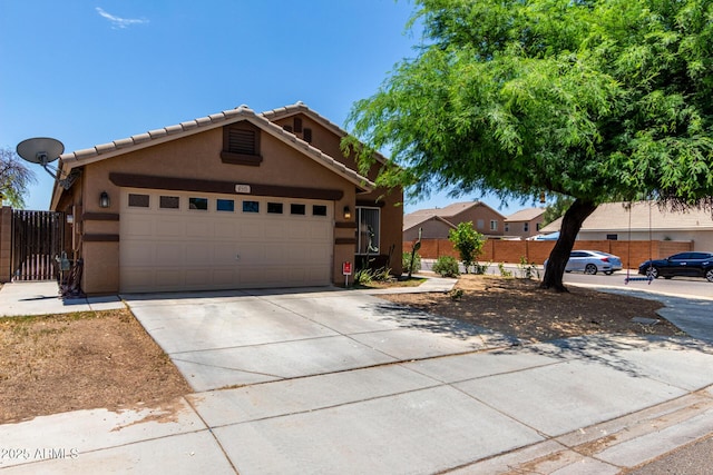 6515 W Hughes Dr, Phoenix, AZ 85043 - view of front of home with stucco siding, driveway, an attached garage, and a gate