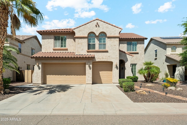 mediterranean / spanish house featuring a tiled roof, a garage, stucco siding, and driveway