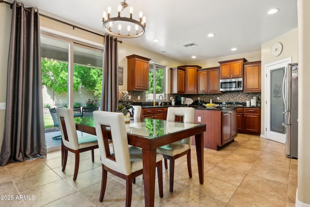 kitchen featuring dark countertops, a notable chandelier, appliances with stainless steel finishes, backsplash, and visible vents