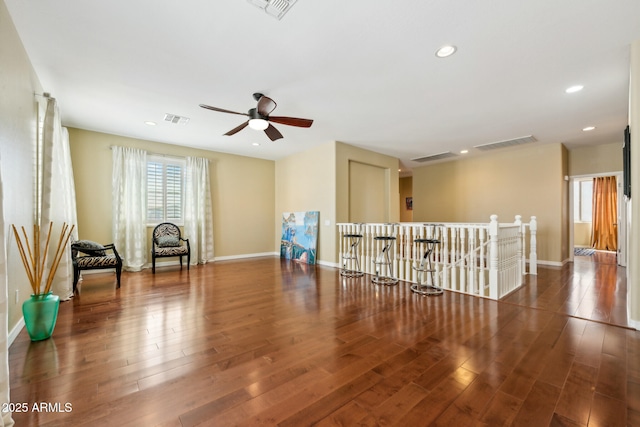 unfurnished room featuring baseboards, visible vents, and wood finished floors