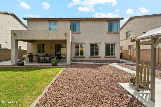 rear view of property featuring a fenced backyard, a patio, stucco siding, and a yard