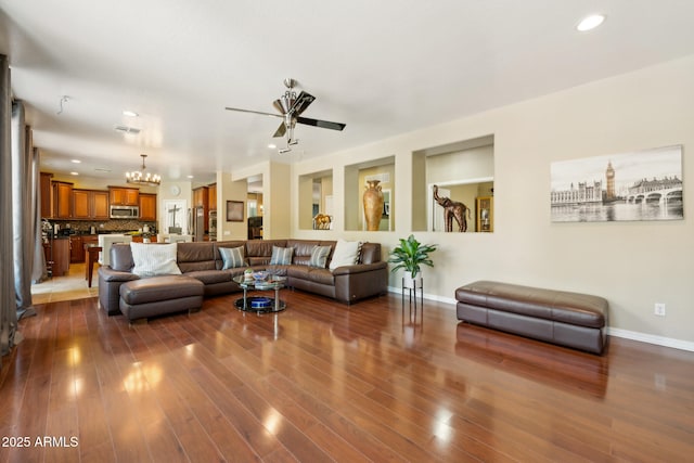 living room featuring dark wood finished floors, ceiling fan with notable chandelier, recessed lighting, baseboards, and visible vents