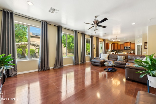 living area with baseboards, recessed lighting, ceiling fan with notable chandelier, and visible vents