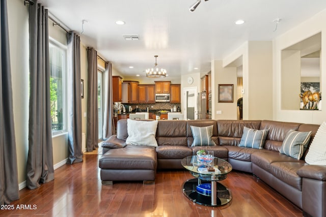 living area with an inviting chandelier, recessed lighting, wood finished floors, and visible vents
